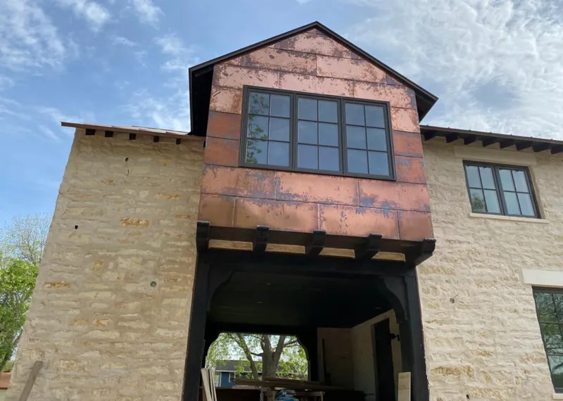 Copper metal panel facade on a stone building for Roof Repair in Mendota